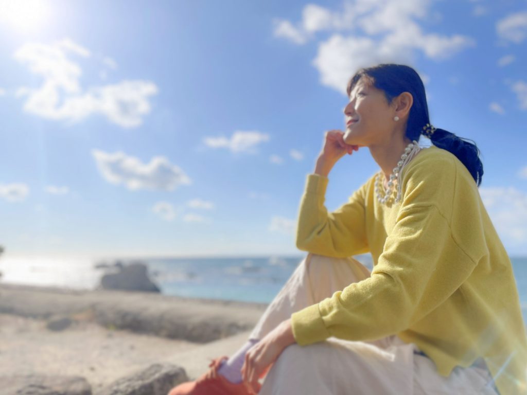 大企業の研修にも採用された”ロジカルな潜在意識の使い方”を提供する「ワンネス株式会社」の50代女性専属ライター。青空をバックに、希望に満ちた笑顔で太陽を見上げる姿